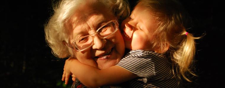 granddaughter hugging grandmother smiling
